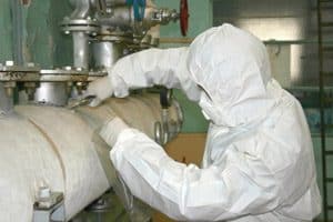 Protected worker evaluating pipe and mechanical insulation in an equipment room