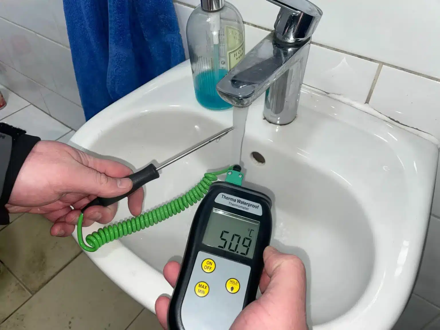 Water temperature being measured at a sink during Legionella testing
